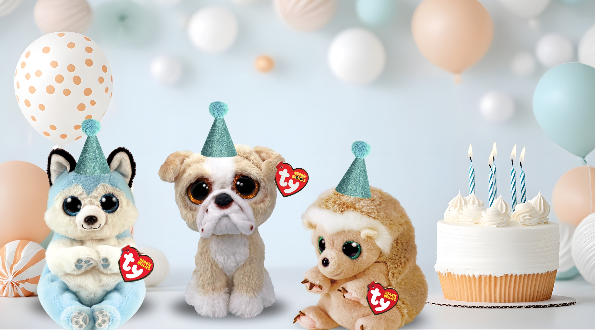 Three beanies with birthday hats and cake and balloons in background