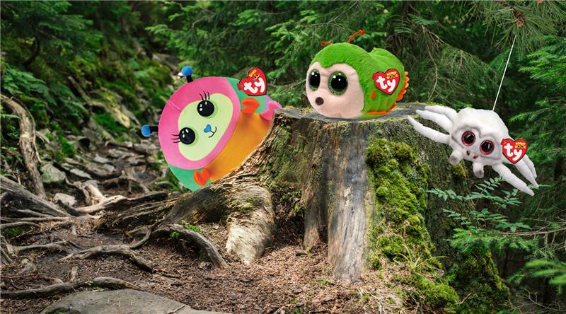 Three plush bug Beanie babies in woodland setting